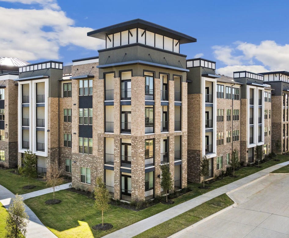 a multi-level building with several windows and a road running alongside it